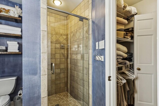 bathroom featuring an enclosed shower and toilet