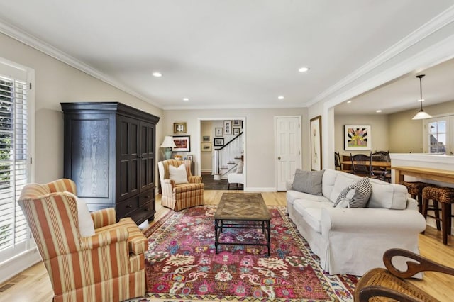 living room featuring crown molding and light hardwood / wood-style flooring