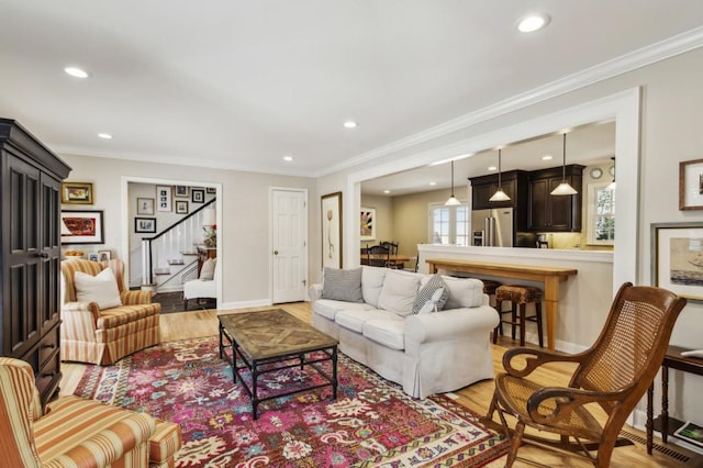 living room with light hardwood / wood-style floors and crown molding