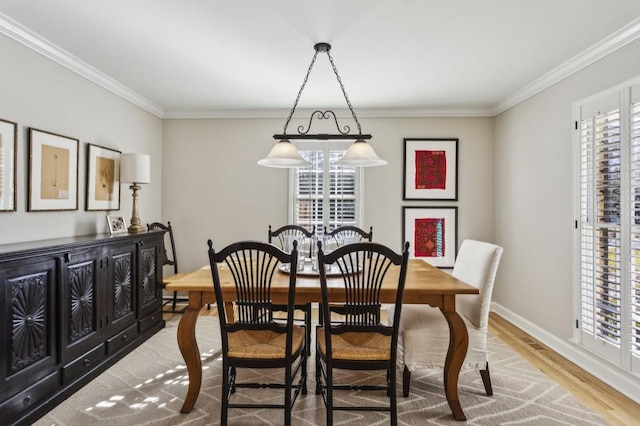 dining space with light wood-type flooring and crown molding