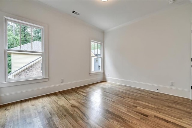 empty room featuring hardwood / wood-style flooring and ornamental molding