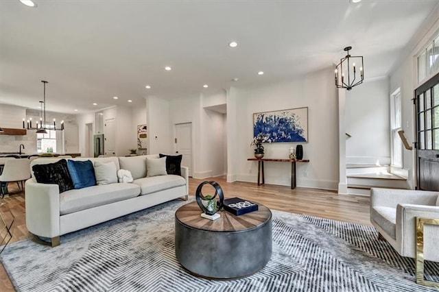 living room with hardwood / wood-style floors and an inviting chandelier