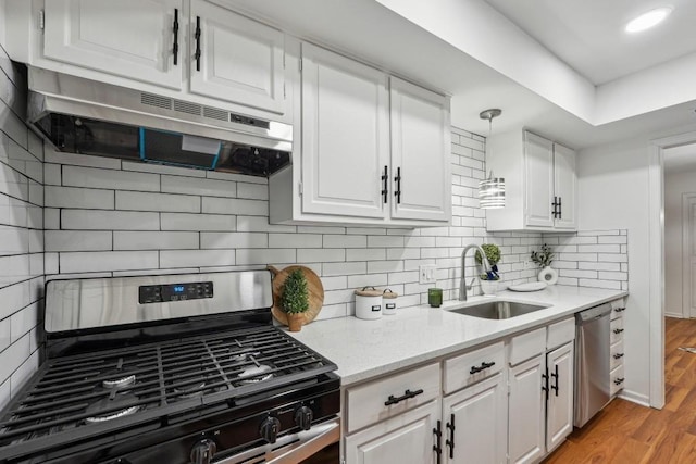 6851 Roswell Rd Unit N-20, Sandy Springs, GA 30328 - kitchen with a sink, appliances with stainless steel finishes, white cabinetry, light wood-style flooring, and decorative backsplash