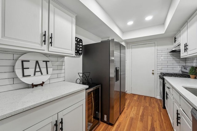 6851 Roswell Rd Unit N-20, Sandy Springs, GA 30328 - kitchen with appliances with stainless steel finishes, tasteful backsplash, white cabinets, light wood finished floors, and recessed lighting