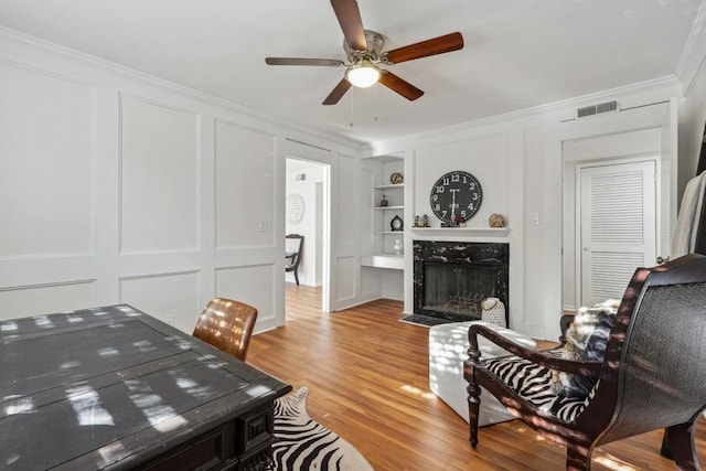 6851 Roswell Rd Unit N-20, Sandy Springs, GA 30328 - living area with a decorative wall, ornamental molding, built in shelves, ceiling fan, and light wood-style flooring
