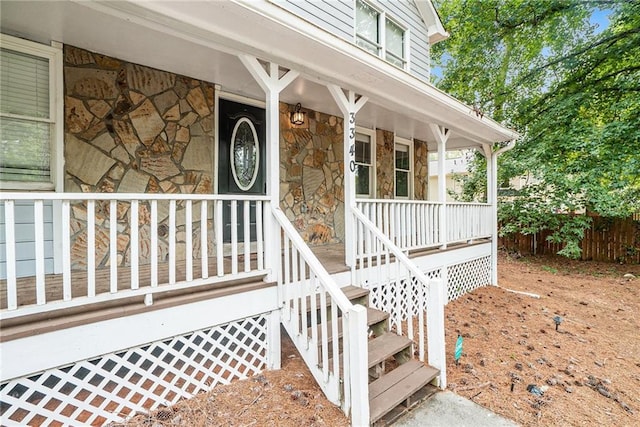 property entrance featuring stone siding and a porch