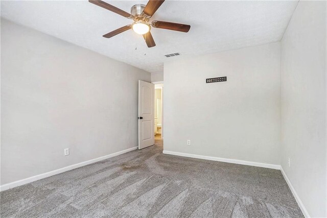 empty room with ceiling fan and carpet flooring