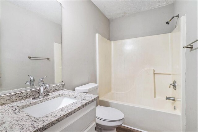 full bathroom with shower / tub combination, toilet, a textured ceiling, and vanity