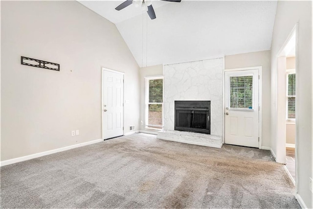 unfurnished living room featuring plenty of natural light, a ceiling fan, and carpet floors