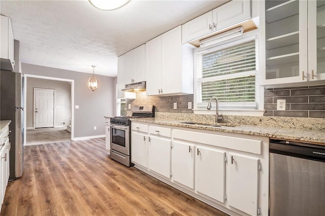 kitchen with stainless steel appliances, light hardwood / wood-style floors, white cabinetry, and sink