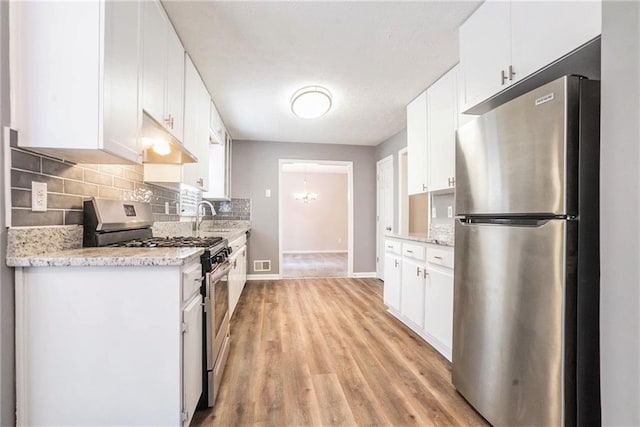 kitchen featuring white cabinets, appliances with stainless steel finishes, and light hardwood / wood-style flooring