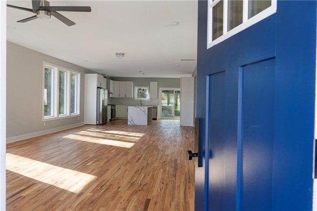 unfurnished living room featuring hardwood / wood-style flooring, plenty of natural light, and ceiling fan