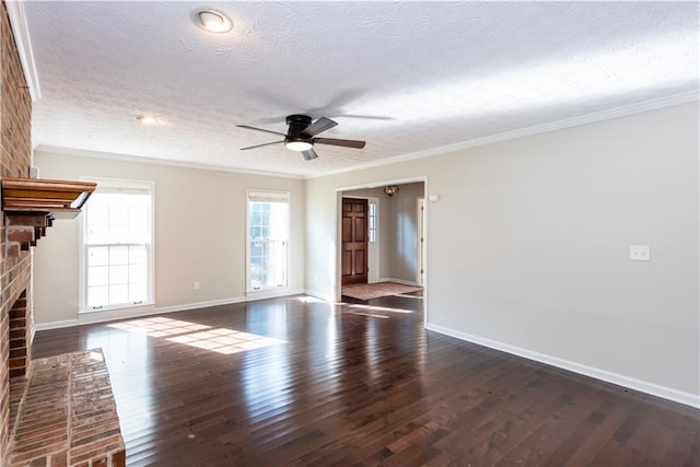 unfurnished living room with a fireplace, dark hardwood / wood-style flooring, ceiling fan, a textured ceiling, and crown molding