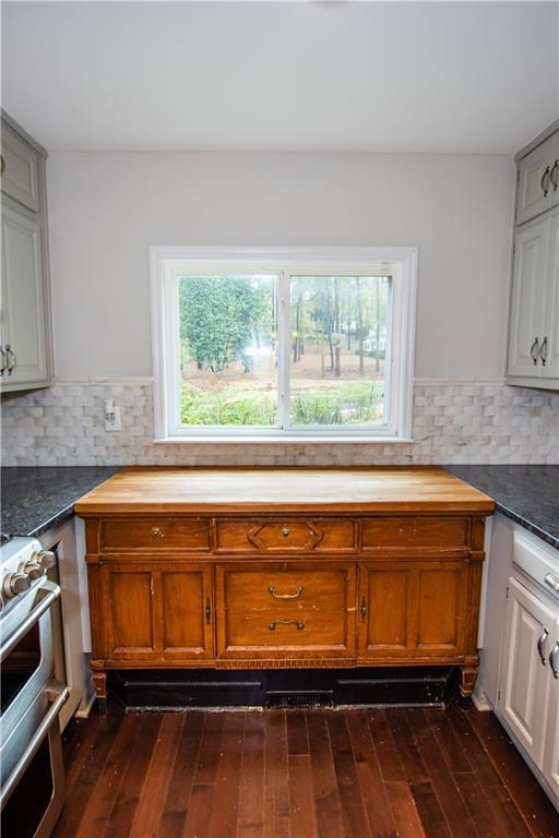 kitchen with plenty of natural light, stainless steel range oven, white cabinetry, and tasteful backsplash