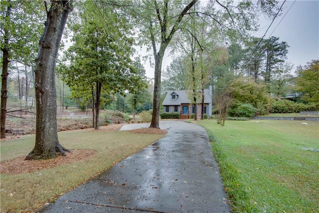 view of front of property with aphalt driveway and a front lawn