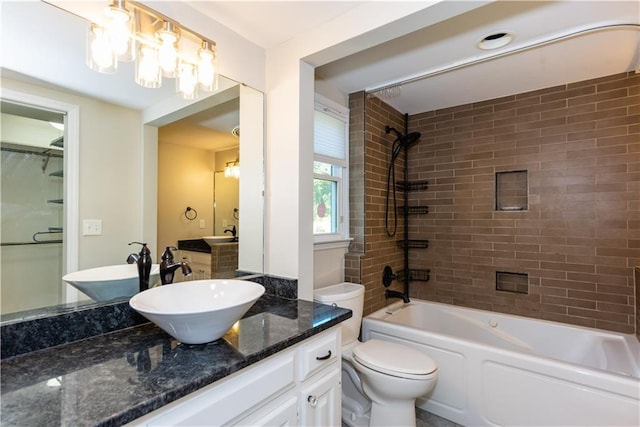 full bathroom featuring toilet, vanity, and tiled shower / bath