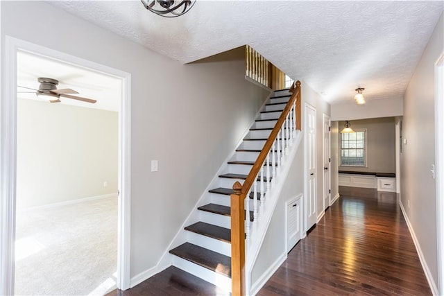 stairs featuring a textured ceiling, ceiling fan, and wood-type flooring