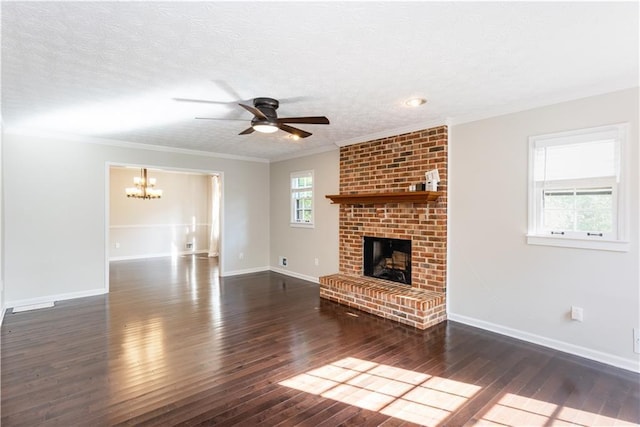 unfurnished living room with a textured ceiling, dark wood-type flooring, ornamental molding, and a fireplace