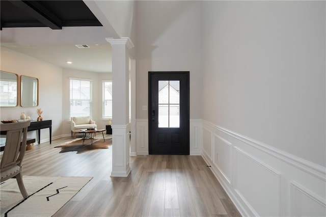 foyer featuring light hardwood / wood-style floors and ornate columns