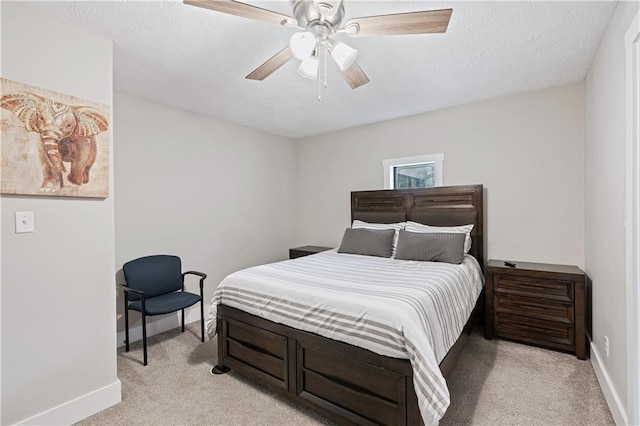 bedroom with light carpet, ceiling fan, baseboards, and a textured ceiling