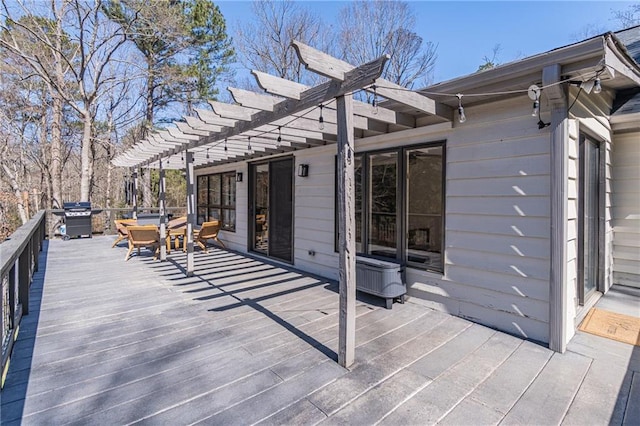 deck featuring a grill and a pergola