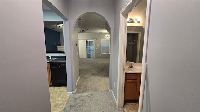 hallway featuring light colored carpet and sink