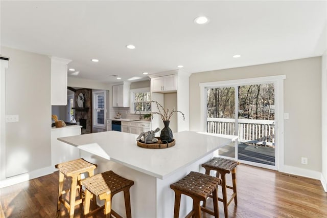 645 Trailmore Pl, Roswell, GA 30076 - kitchen with dark wood-style floors, light countertops, a breakfast bar, and white cabinets