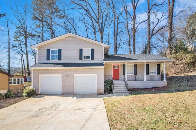 tri-level home featuring a front lawn, a porch, and a garage