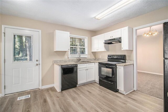 kitchen with light stone counters, sink, white cabinets, and black appliances