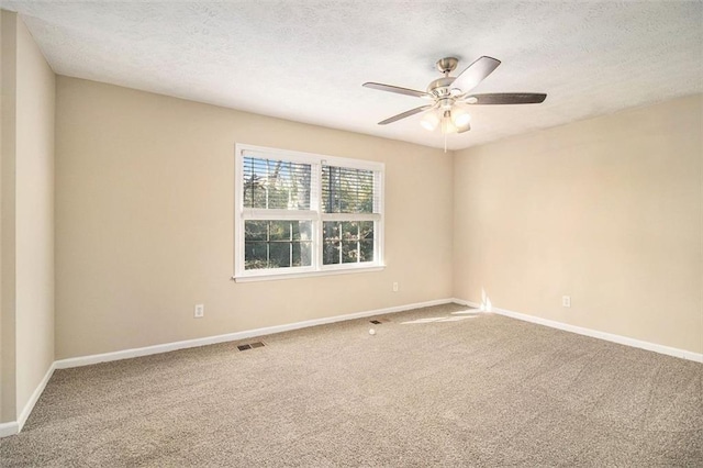 carpeted spare room with ceiling fan and a textured ceiling