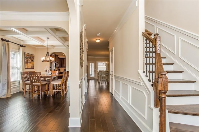 dining area featuring a healthy amount of sunlight, dark hardwood / wood-style flooring, beamed ceiling, and coffered ceiling