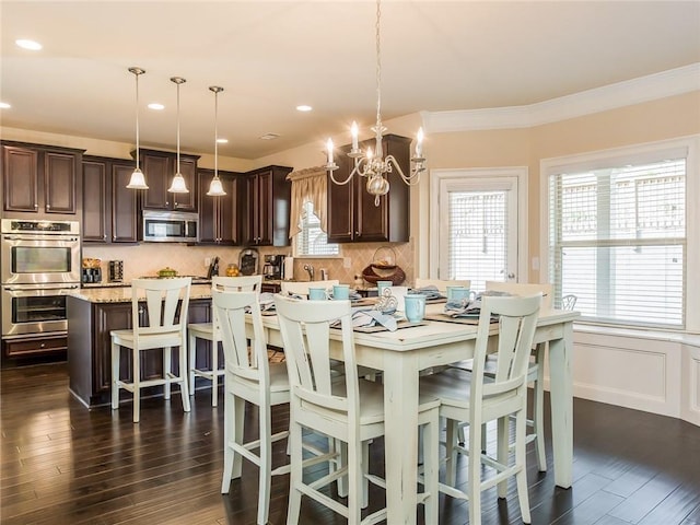 dining space featuring ornamental molding, dark hardwood / wood-style flooring, and an inviting chandelier