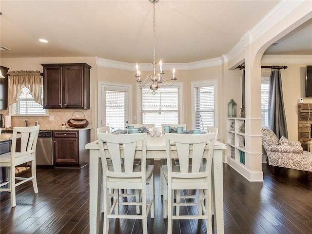 dining space with a notable chandelier, crown molding, and dark hardwood / wood-style floors