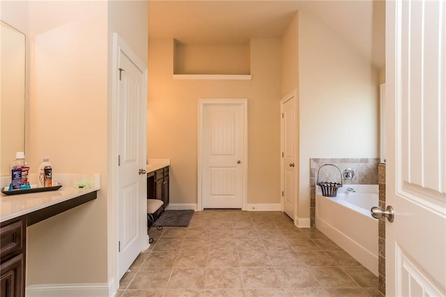 bathroom featuring a washtub, tile patterned floors, and vanity