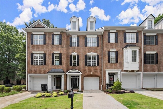 2303 Waters Edge Trl, Roswell, GA 30075 - townhome / multi-family property featuring brick siding, a front lawn, driveway, and a garage