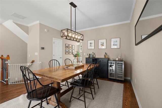 2303 Waters Edge Trl, Roswell, GA 30075 - dining area featuring beverage cooler, wood finished floors, ornamental molding, bar area, and baseboards