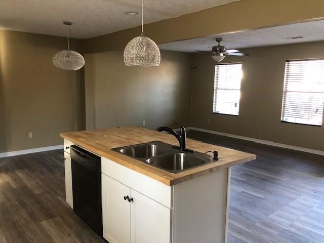 kitchen with sink, hanging light fixtures, black dishwasher, an island with sink, and white cabinets