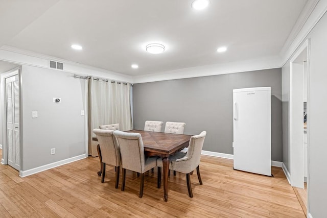 dining room featuring light hardwood / wood-style floors and ornamental molding