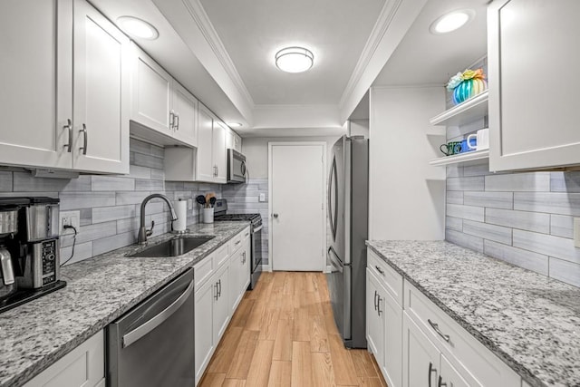 kitchen featuring sink, stainless steel appliances, light stone counters, white cabinets, and ornamental molding