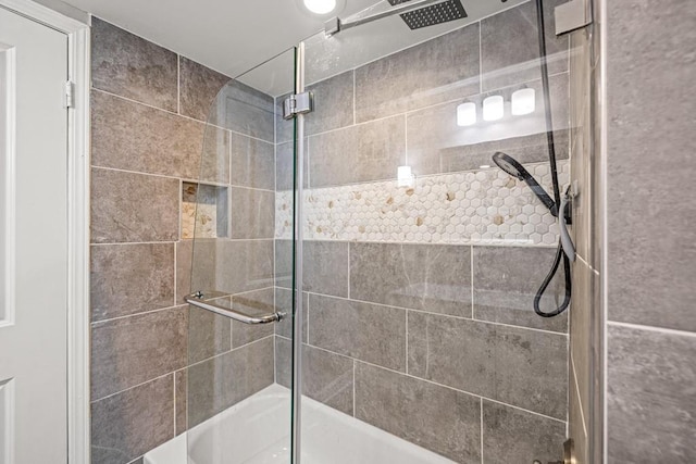 bathroom featuring combined bath / shower with glass door