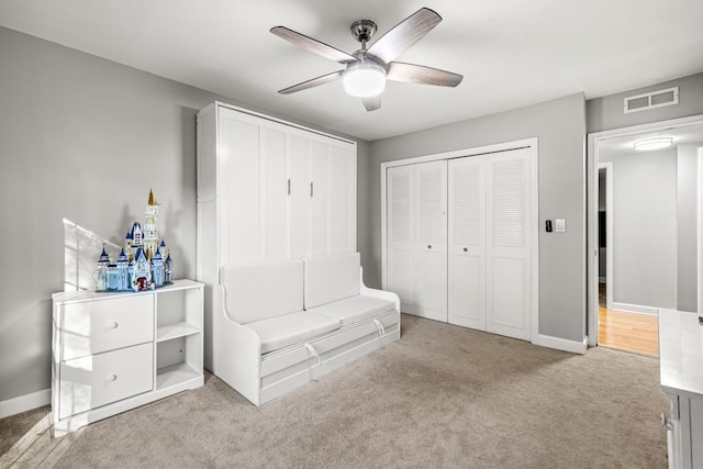 unfurnished bedroom with ceiling fan, a closet, and light carpet