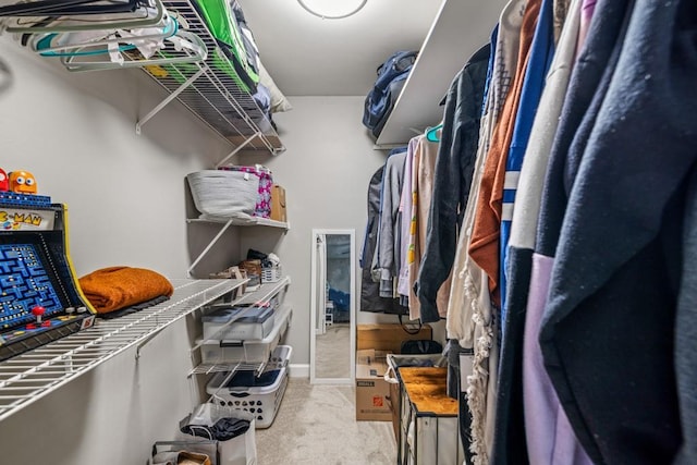 walk in closet featuring light colored carpet