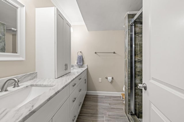 bathroom featuring ornamental molding, vanity, hardwood / wood-style flooring, and a shower with shower door