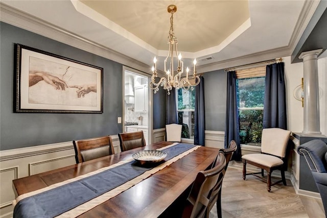 127 Bradshaw Park Dr, Woodstock, GA 30188 - dining room featuring a raised ceiling, a chandelier, ornamental molding, wainscoting, and ornate columns