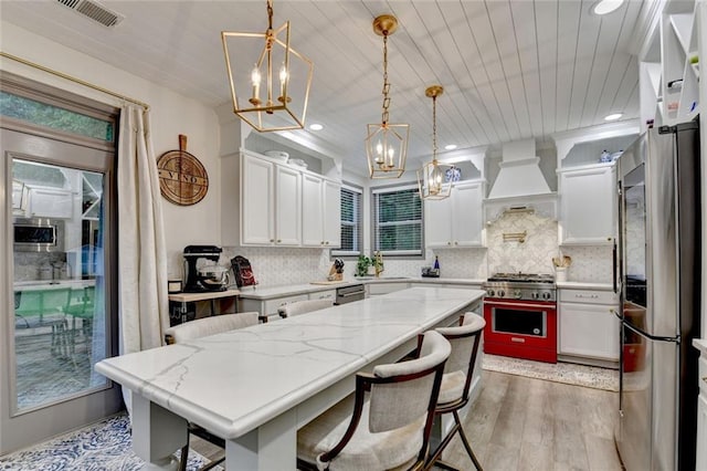 127 Bradshaw Park Dr, Woodstock, GA 30188 - kitchen with a chandelier, appliances with stainless steel finishes, custom range hood, light wood finished floors, and recessed lighting