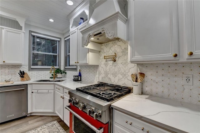 127 Bradshaw Park Dr, Woodstock, GA 30188 - kitchen featuring appliances with stainless steel finishes, light wood-style floors, white cabinets, premium range hood, and decorative backsplash