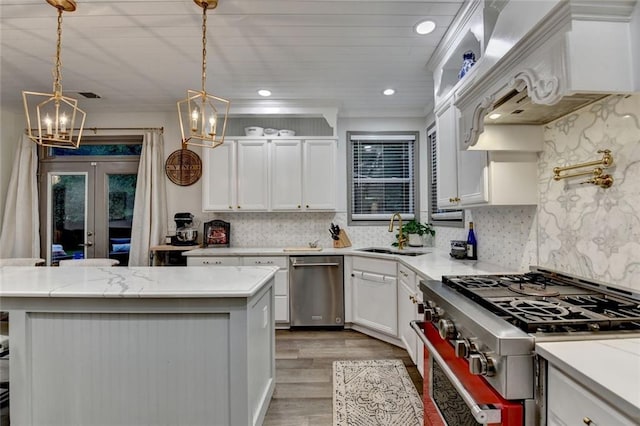 127 Bradshaw Park Dr, Woodstock, GA 30188 - kitchen with appliances with stainless steel finishes, light wood-style flooring, white cabinets, decorative backsplash, and a chandelier