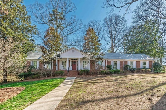 view of front facade featuring a front lawn, a porch, and brick siding