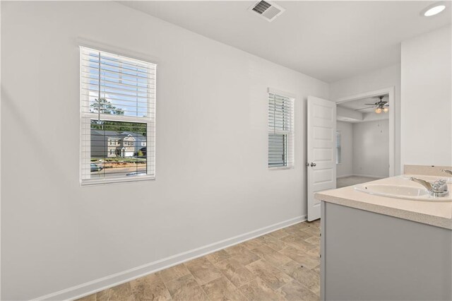 bathroom featuring a sink, baseboards, ceiling fan, and visible vents