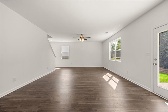 unfurnished living room with dark wood finished floors, baseboards, and ceiling fan